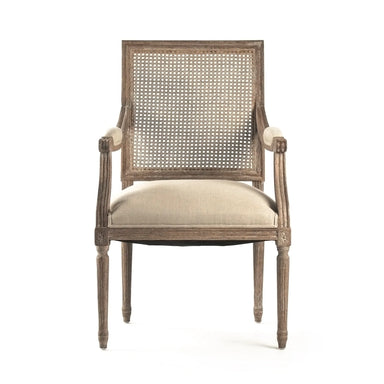 A classic French-style armchair with a distressed gray-brown wood frame, a woven cane backrest, and a light beige upholstered seat cushion, shown against a plain white background.